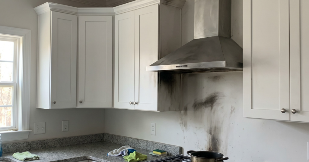 Slightly upscale Georgia kitchen with visible soot above range after a small stovetop fire for smoke and fire claim documentation.