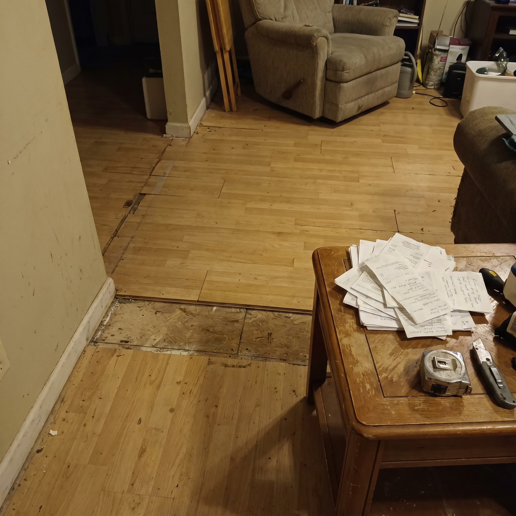 Candid interior repair documentation scene with flooring repair and non-readable repair papers