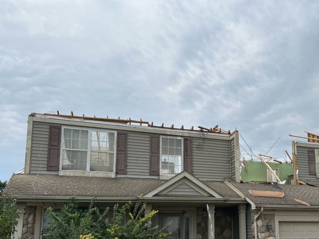 Residence with roof sections removed and exposed framing in an NWS Chicago storm-survey photograph