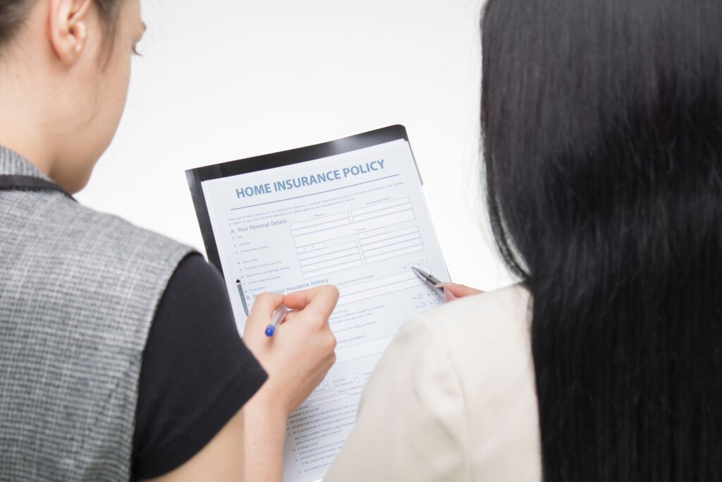 Stock photo of two people reviewing a blank home insurance form; models, not clients or lawsuit participants.