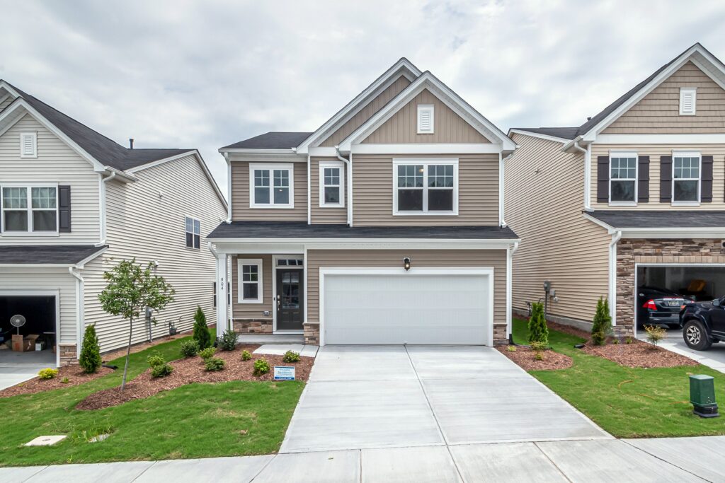 A two story suburban home with siding, a garage and lawn. Illustrative stock property, not the damaged home described in the example.